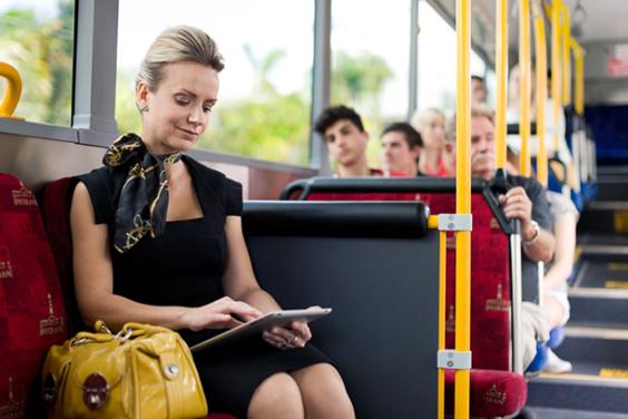 Lady seated on the bus using her ipad