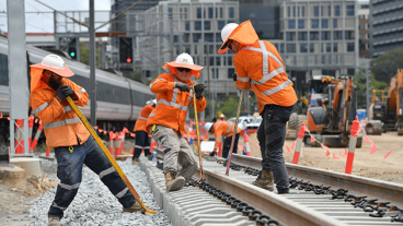 Three workers fixing a train track